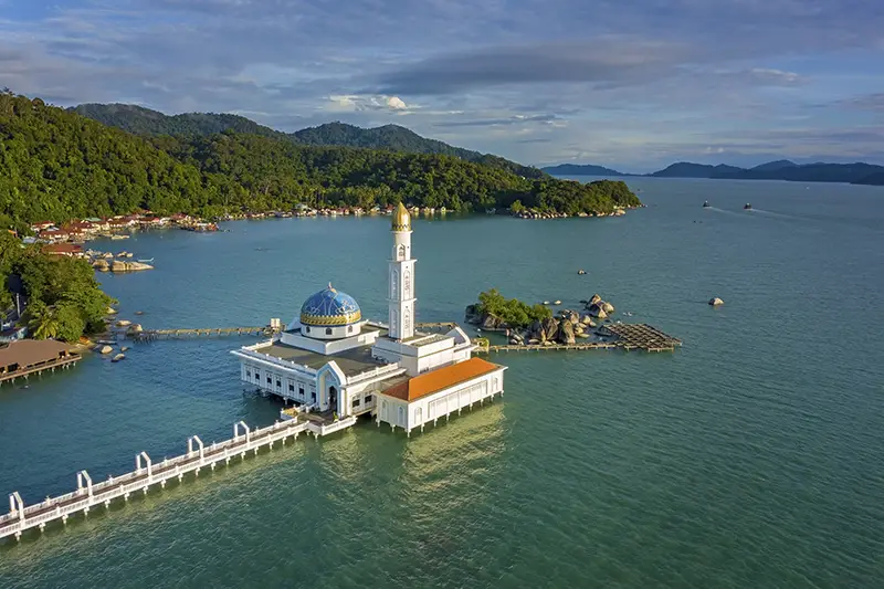 Aerial view of the Floating Mosque on Pangkor Island, surrounded by calm waters and lush green hills in the background