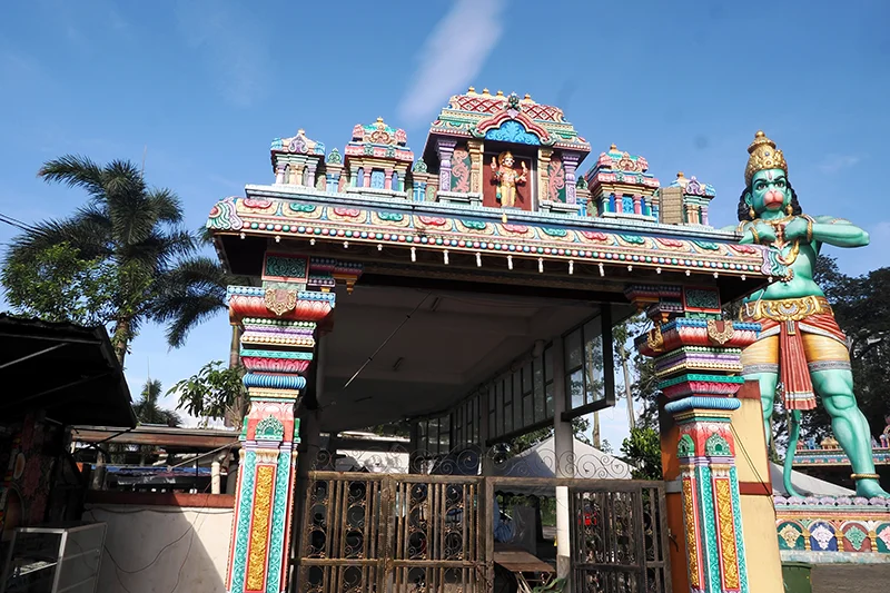 Hanuman temple with colorful gopuram and towering green Hanuman statue at Batu Caves, one of the attractions seen during a Batu Caves tour