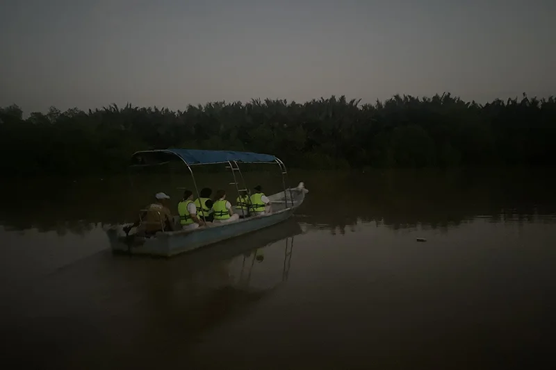 Tourists on a boat at Bukit Belimbing Firefly Park heading toward the mangrove forest to watch fireflies.
