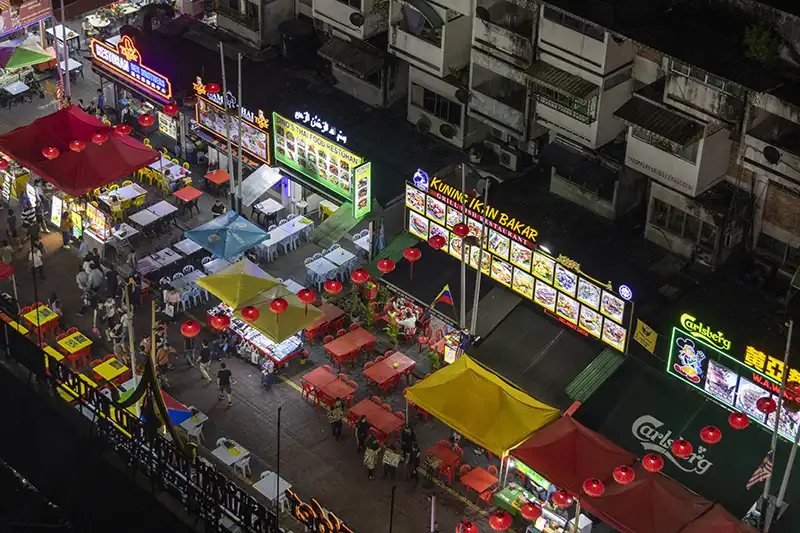 Jalan Alor night market in Kuala Lumpur showcasing the best street food in Malaysia with colorful food stalls and neon lights.