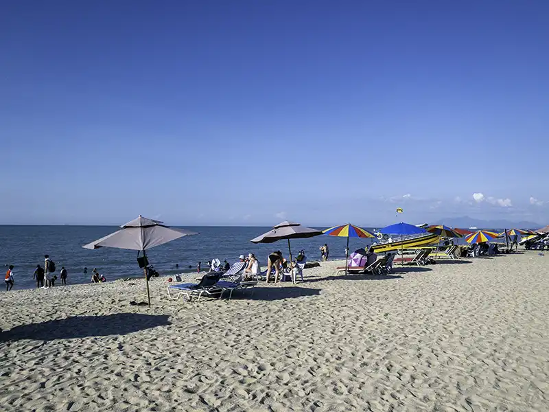 Batu Ferringhi beach in Penang with sandy shoreline, sun umbrellas, and sea view