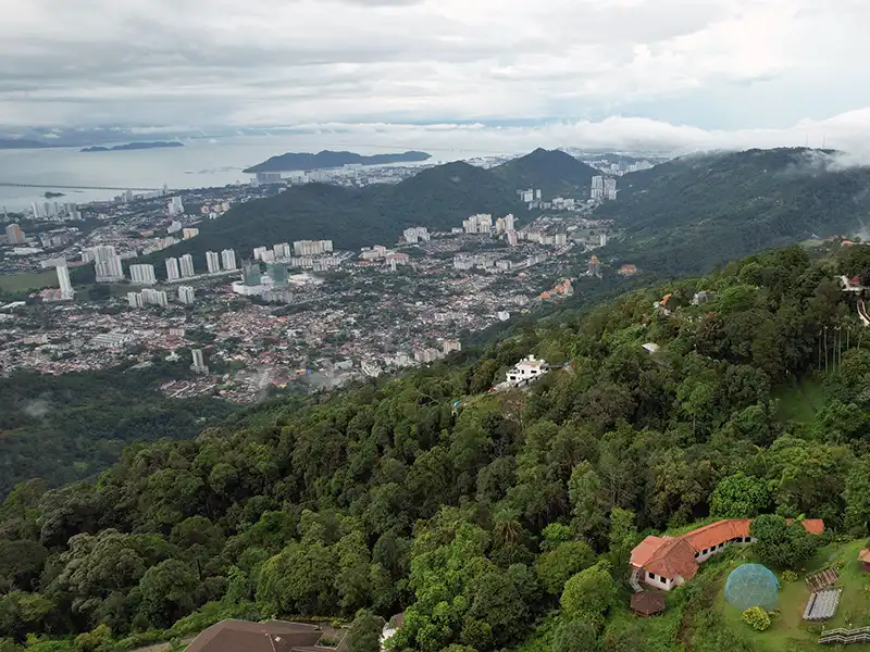 View of George Town and Penang Island from Penang Hill surrounded by forested hills