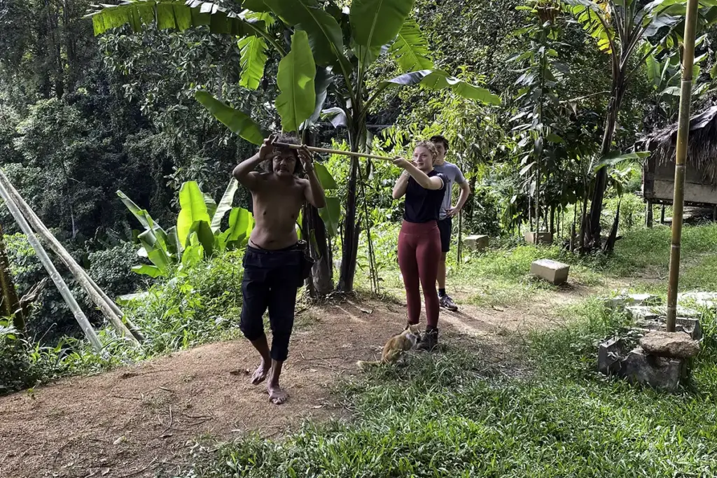 Visitors taking part in a traditional blowpipe activity in a rural area of Malaysia